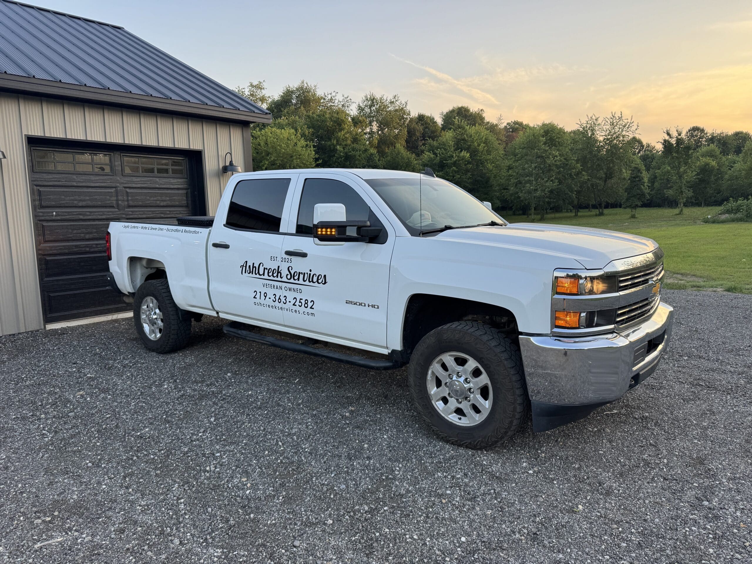 AshCreek Services work truck parked outside showcasing local septic, sewer, water line, and excavation services